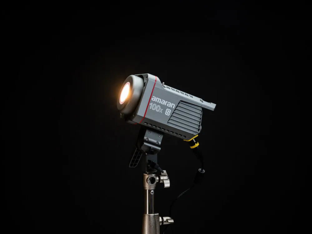Close-up of the Aputure Amaran 100x S LED light with its reflector, positioned on a light stand during a content creation shoot, emphasizing its robust build and ease of setup.