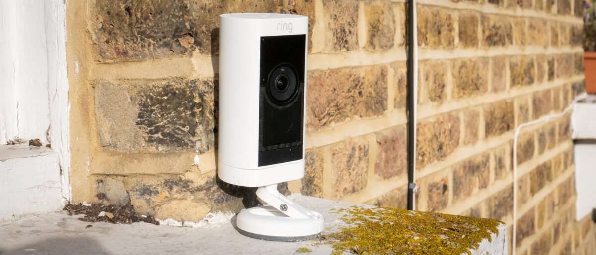 The Ring Stick Up Cam Battery mounted outdoors on a wall, providing security surveillance over a residential entrance, demonstrating its weather-resistant design and wide field of view.