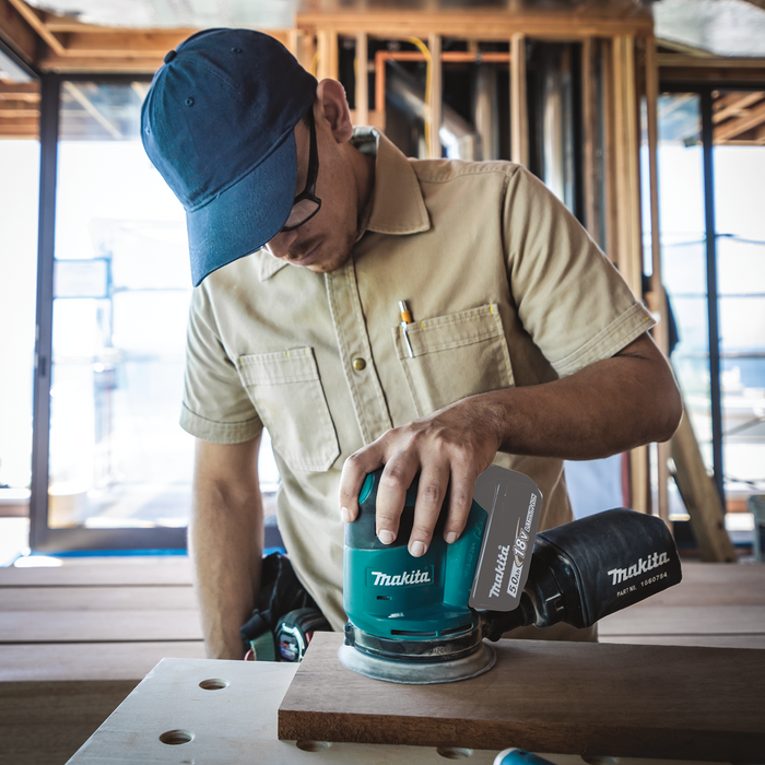 Makita XOB01Z 18V LXT Brushless 5 Random Orbital Sander displayed prominently on a clean background, highlighting its ergonomic design and compact form factor.