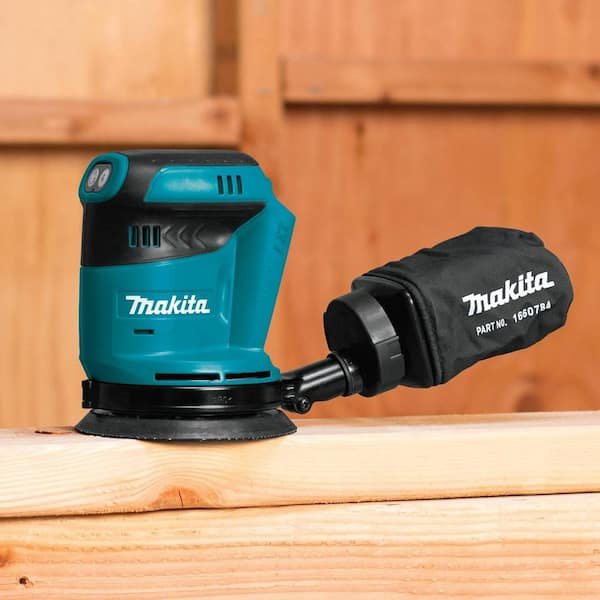 Close-up view of the Makita XOB01Z 18V LXT Brushless 5 Random Orbital Sander's ergonomic grip and power switch, emphasizing user control and comfort during operation.