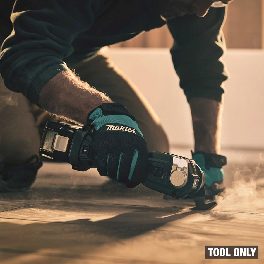 Makita XMT04Z 18V LXT Cordless Multi-Tool in action, cutting through tile with dust visible, demonstrating its real-world application.